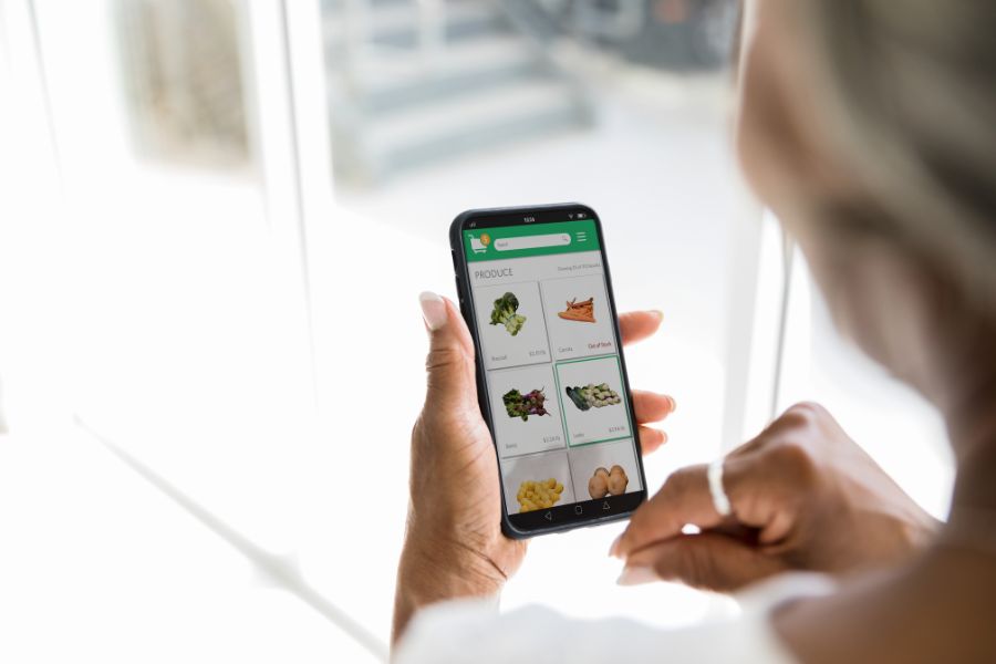 Woman using grocery delivery app on her smartphone