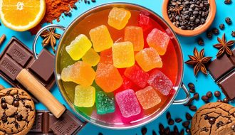 A variety of vibrant THC gummies gently melting over a saucepan, surrounded by ingredients like chocolate chunks, cookies, and spices, symbolizing the infusion of cannabis into culinary creations.